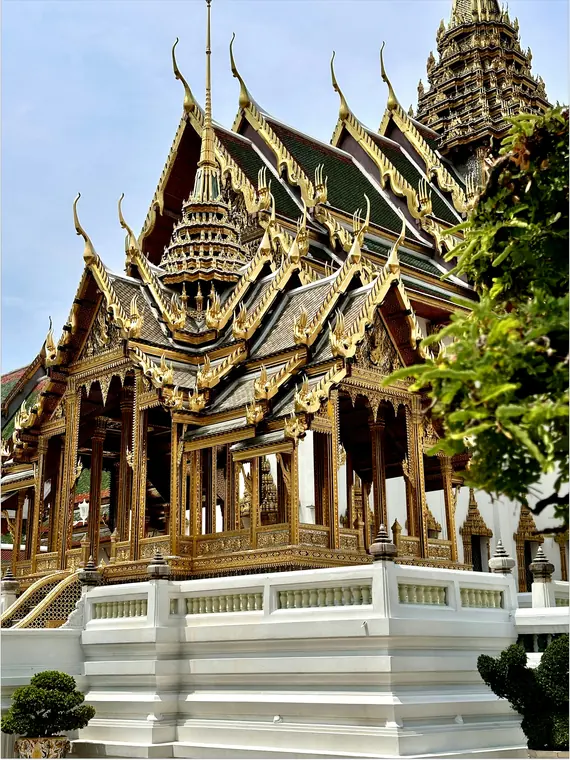 Grand Palace and golden spires of Wat Phra Kaew in Bangkok under clear blue sky