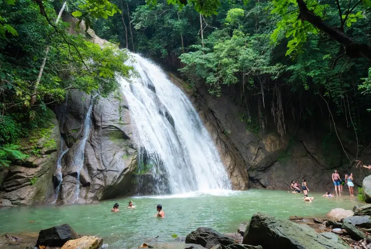 Khlong Phlu Waterfall on Koh Chang with people swimming in the jungle pool