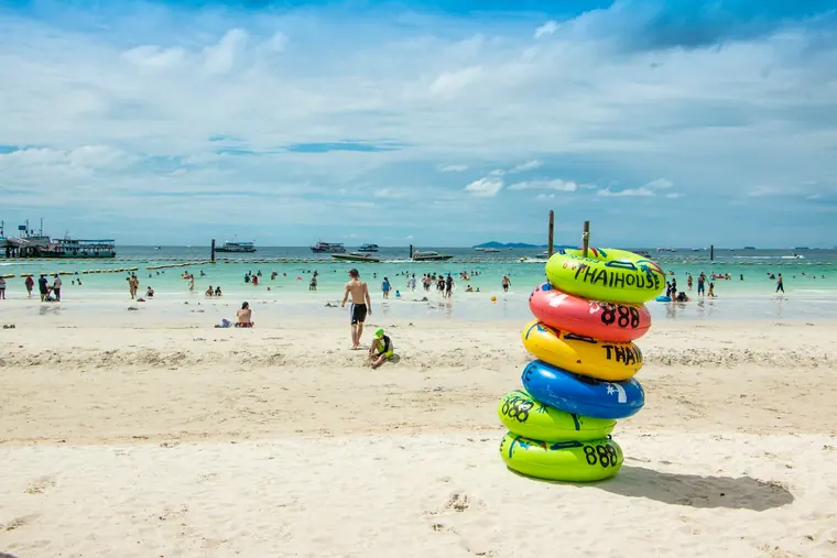 Tawaen Beach on Koh Larn with white sand, turquoise water and thatched umbrellas