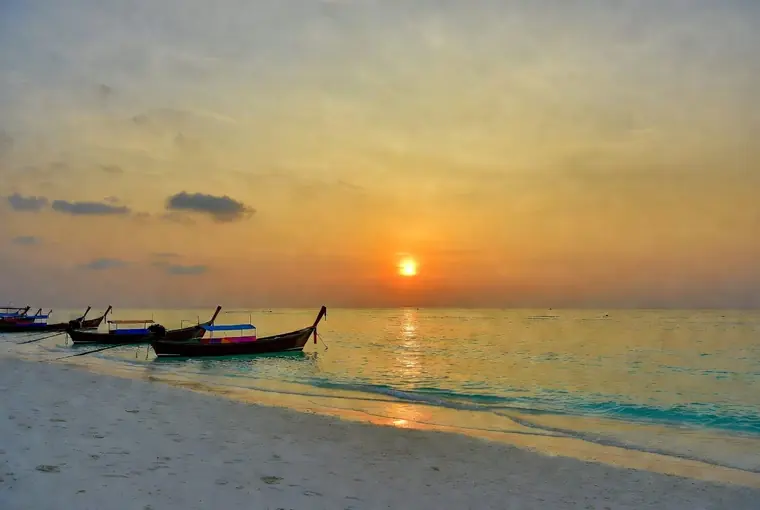 Sunrise Beach on Koh Lipe with longtail boats and golden light