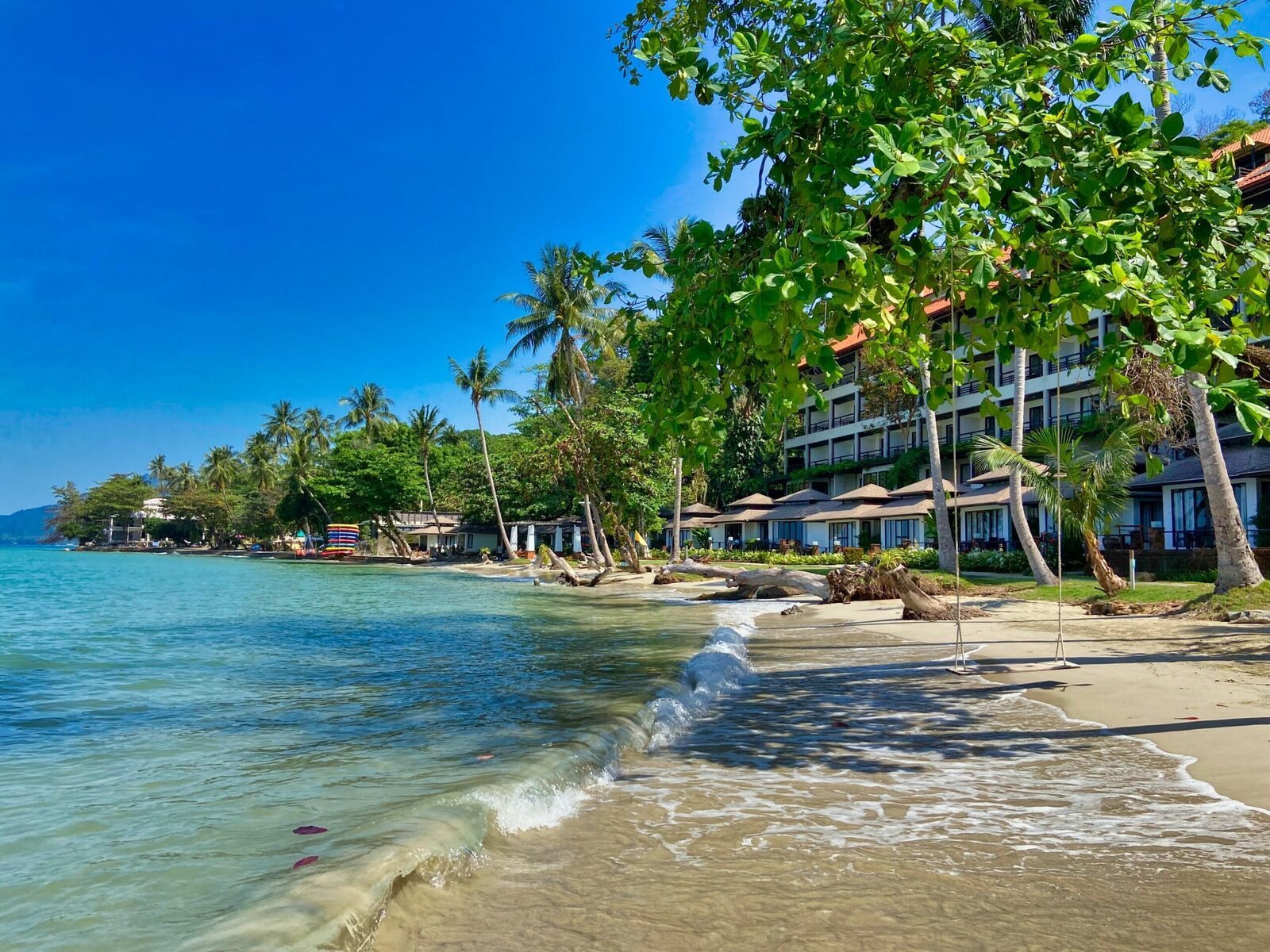 Palm-lined beach and beachfront resort on Koh Chang, one of the eastern Gulf Thailand islands that stays sheltered during the August monsoon