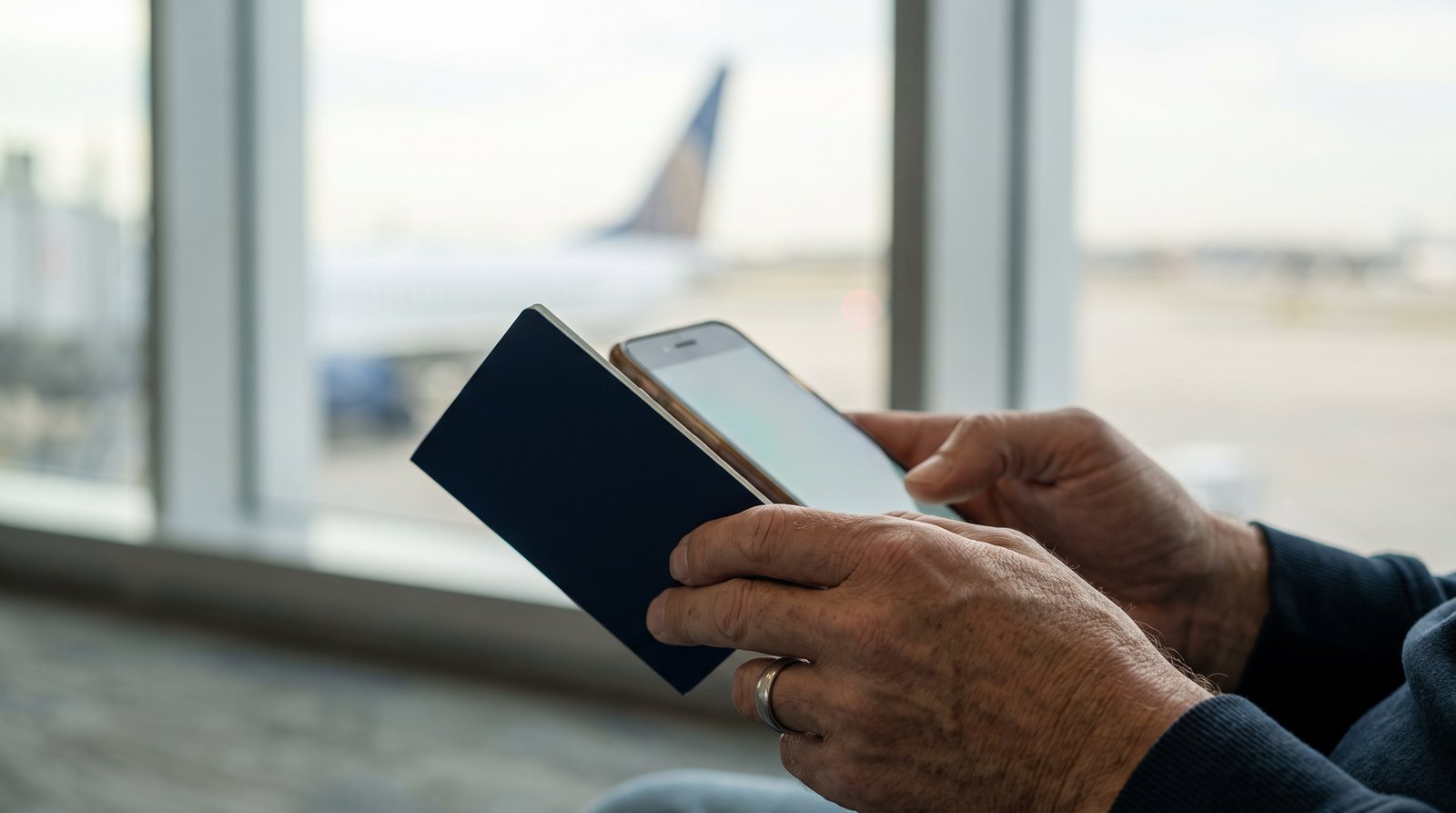 A traveller completing the Thailand Digital Arrival Card on a smartphone with a passport in hand before departure