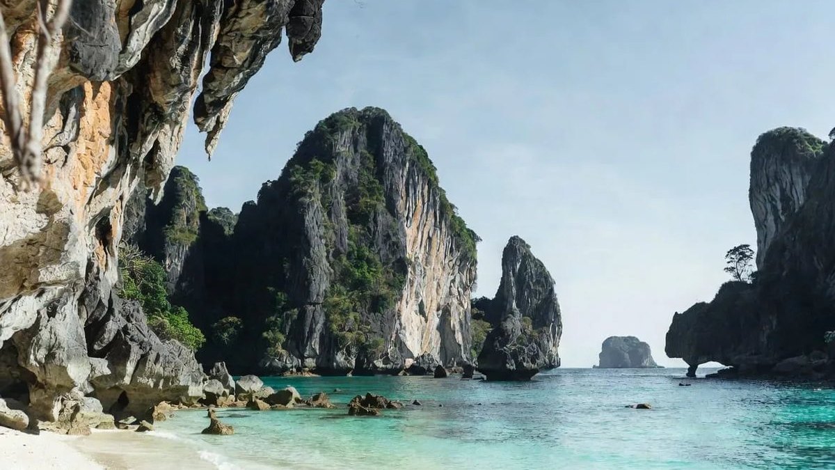 White sand beach, clear turquoise water and towering limestone cliffs on Thailand's Andaman coast, the region reopening for the 2026-27 season in this Thailand travel news update