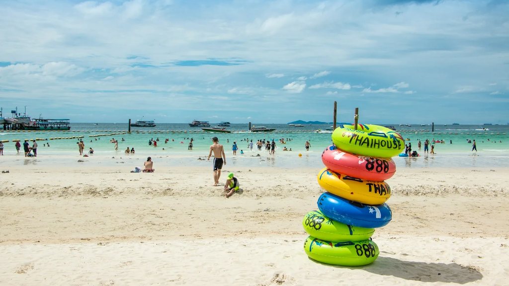 Tawaen Beach on Koh Larn with white sand, swimmers, speedboats offshore and a stack of coloured rubber rings, one of the classic things to do in Pattaya