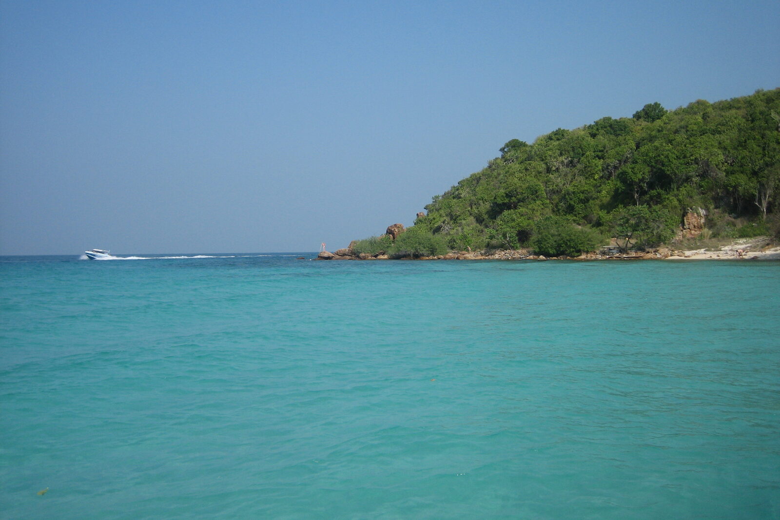 Clear turquoise water and a forested headland at Koh Larn near Pattaya, the closest of the Thailand islands to the city