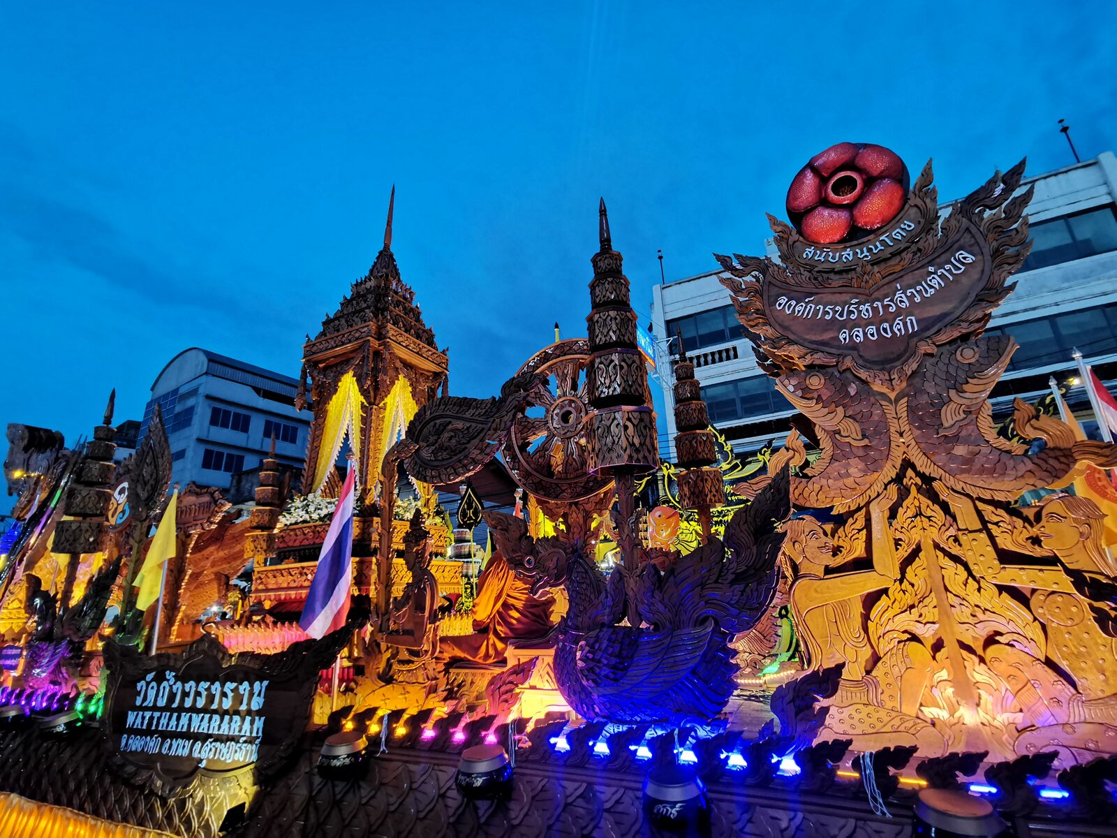 Rows of illuminated Chak Phra temple floats with gilded spires and carved naga figures lit up at dusk in central Surat Thani, a highlight of Thai culture among the best places to visit in Thailand in October