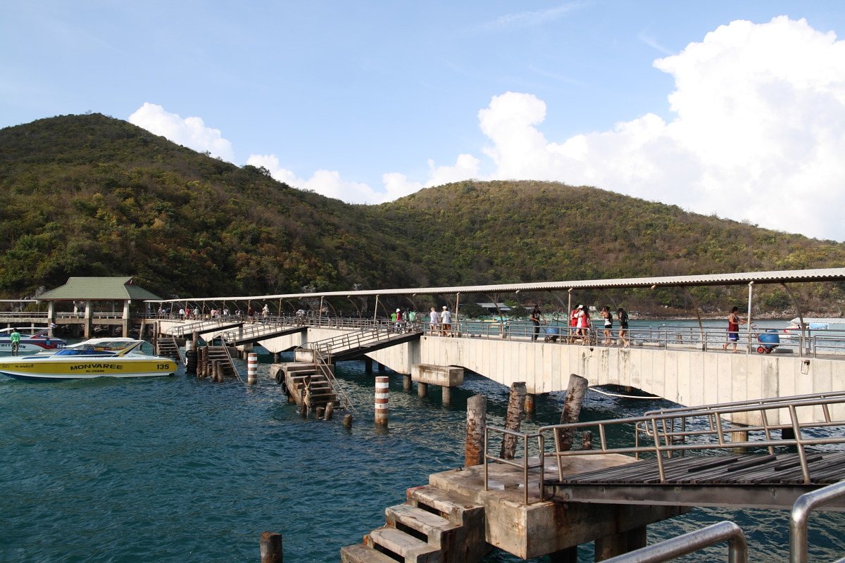 The pier and floating pontoon at Na Ban on Koh Larn with passenger boats alongside and green hills behind, the island terminal due a 3-million-baht rebuild in this Pattaya travel guide update