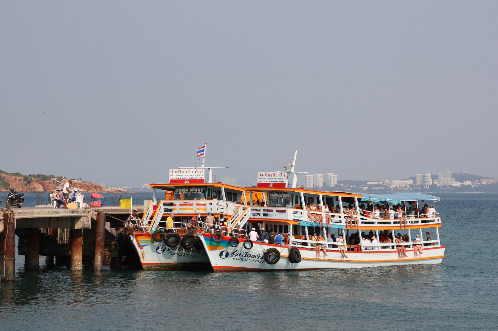 Wooden Koh Larn passenger ferries moored side by side at Bali Hai Pier in Pattaya with the bay and headland behind, the departure point in any Pattaya travel guide