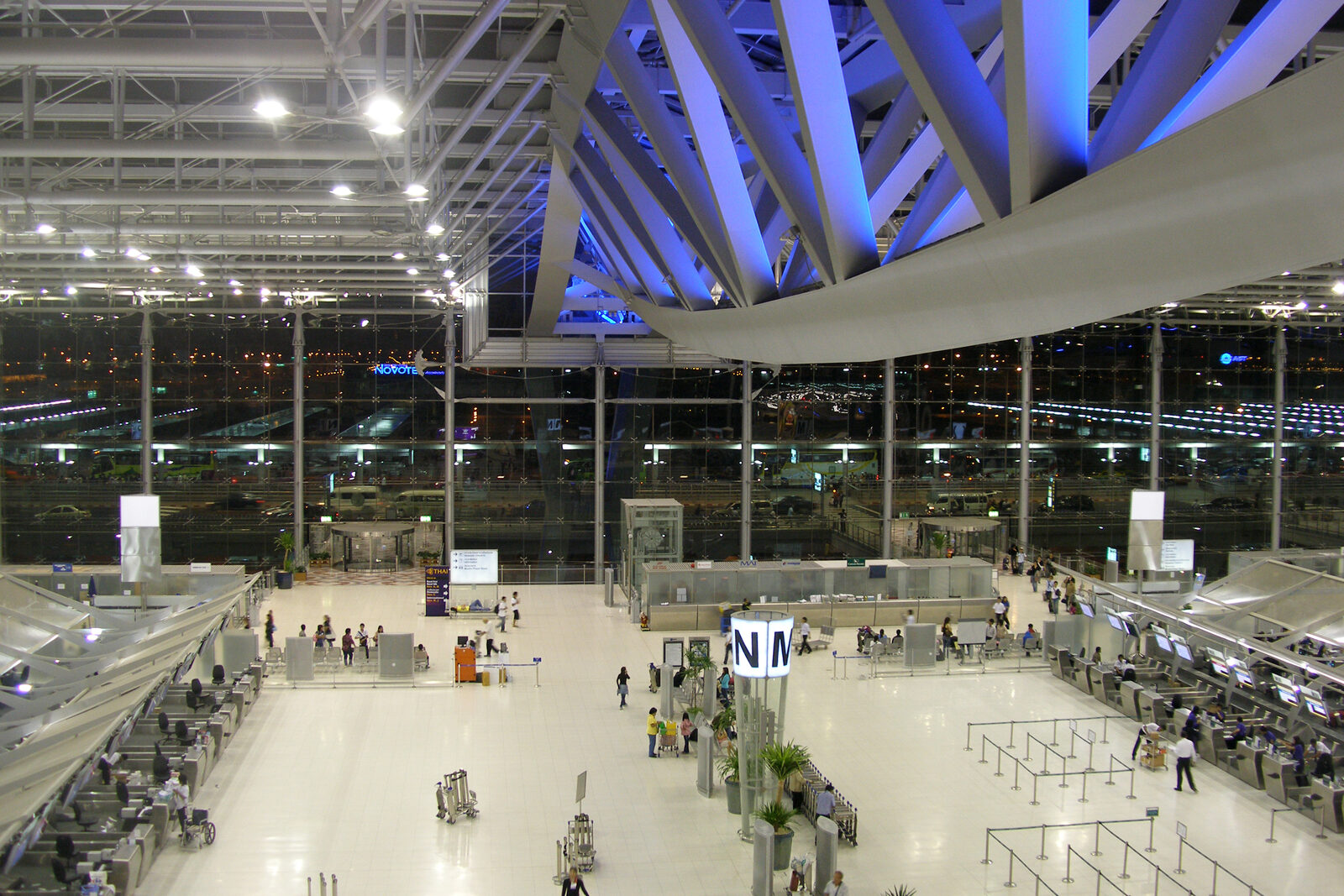 The vast check-in hall at Suvarnabhumi Airport in Bangkok lit at night, where the Thai Airways cancellations of late September 2026 left passengers queuing, a key location in this Thailand travel news update