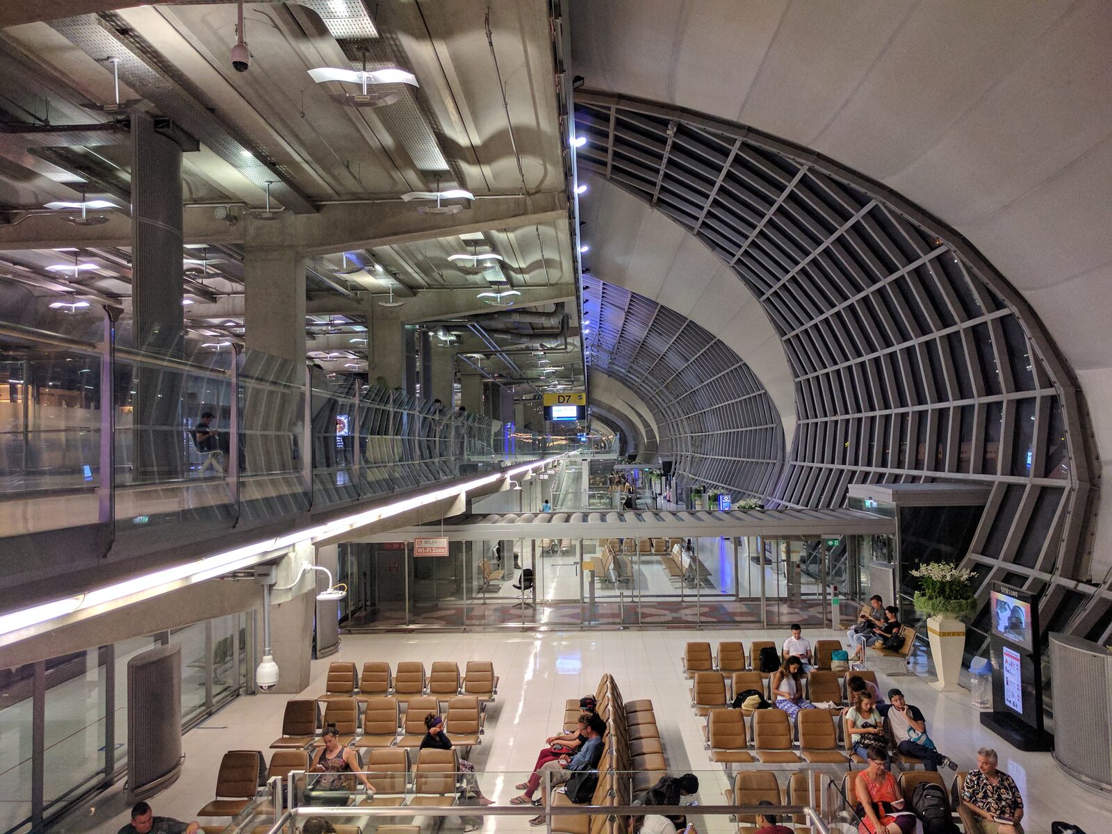 Travellers waiting in the curved Terminal D gate area at Suvarnabhumi Airport in Bangkok, the departure concourse most visitors pass through when they travel to Thailand