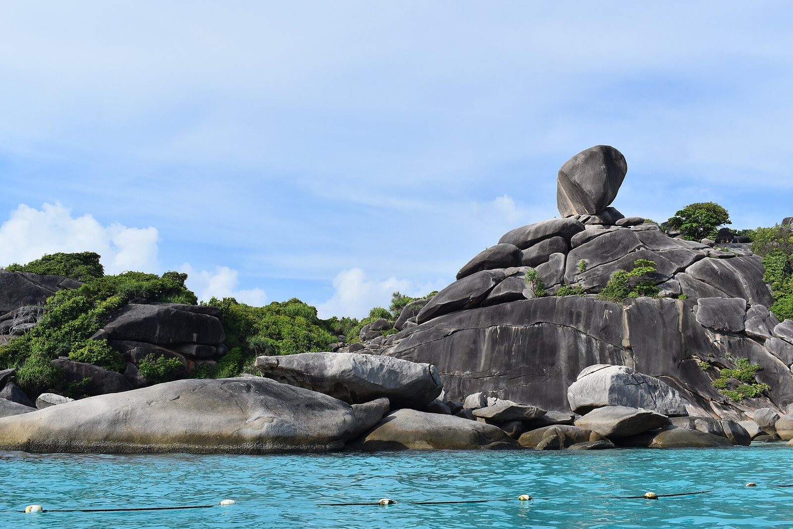 Sail Rock, the balanced granite boulder above Donald Duck Bay on Koh Similan island 8, with turquoise water and snorkelling marker buoys below, the centrepiece of this Thailand tourism update on the Similan Islands reopening