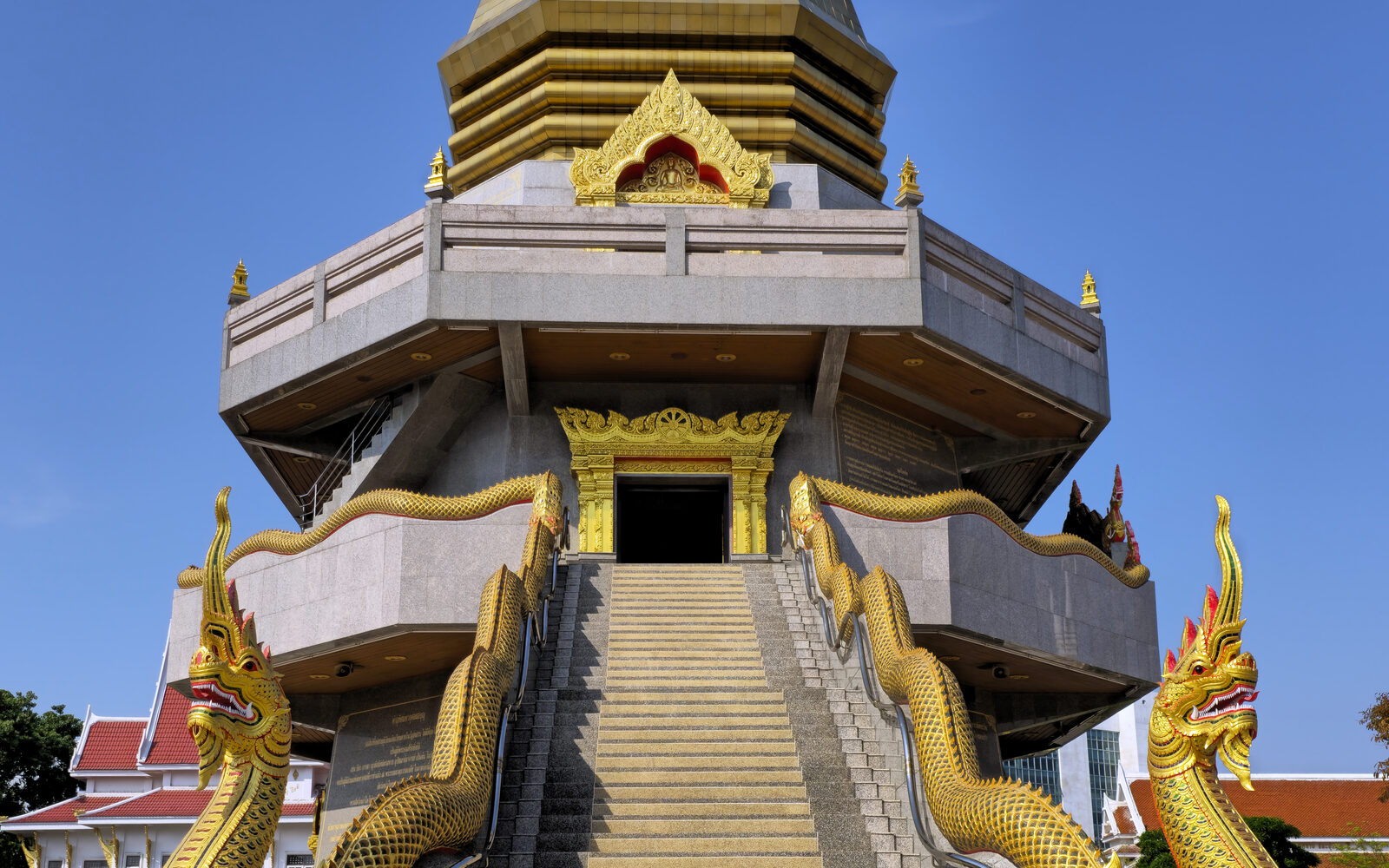 The gilded chedi and naga-flanked staircase of Wat Phothisomphon in Udon Thani under a clear blue sky, the city landmark closest to the Thai festivals 2026 horticultural expo site