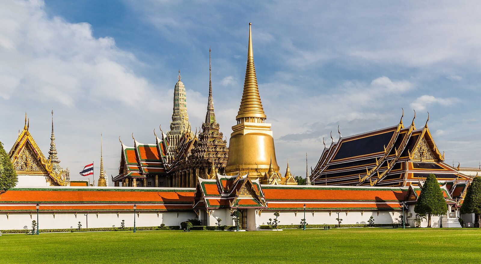 The golden Phra Si Rattana chedi and orange-tiled roofs of the Grand Palace and Temple of the Emerald Buddha in Bangkok under a blue sky, the centrepiece of the planned City Express layover tour