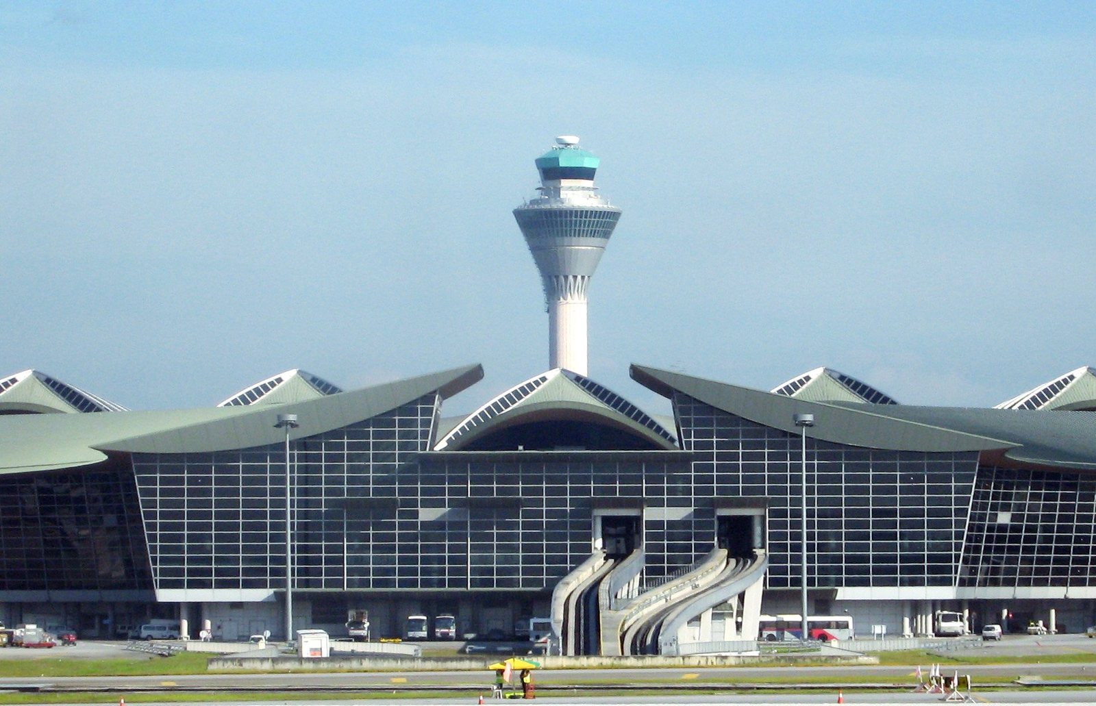 The curved roofline and control tower of Kuala Lumpur International Airport under a blue sky, departure point for the new daily Thai Vietjet flights to Bangkok