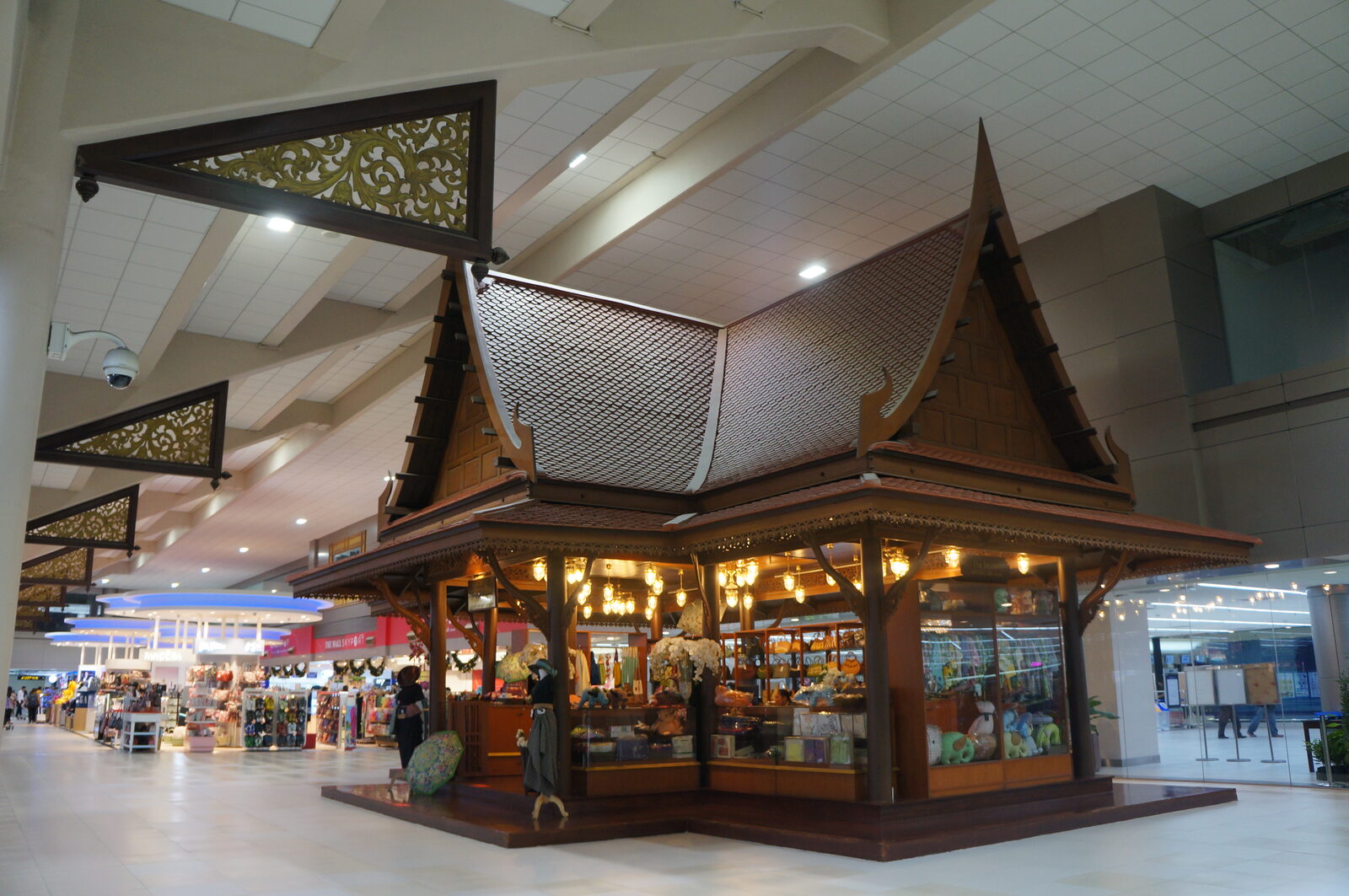 The domestic terminal concourse at Don Mueang International Airport in Bangkok, with a traditional Thai-style wooden pavilion housing a souvenir shop, the hub for low-cost domestic flights in Thailand
