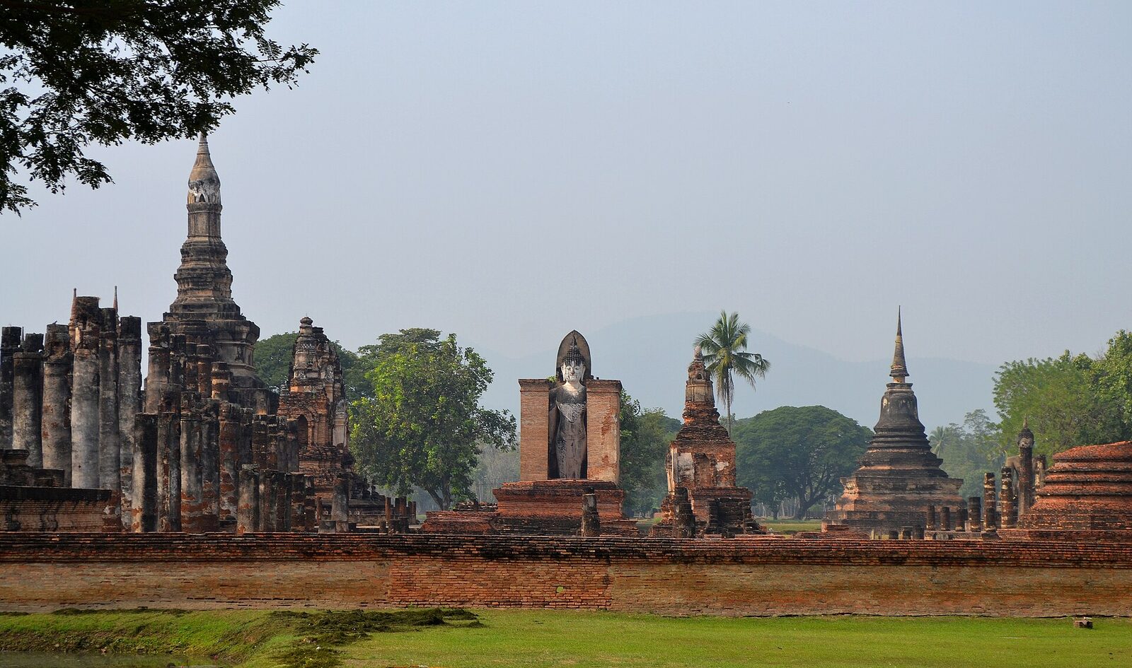 The columns, standing Buddha and bell-shaped chedis of Wat Mahathat in Sukhothai Historical Park, venue of the Loy Krathong Light and Sound Show