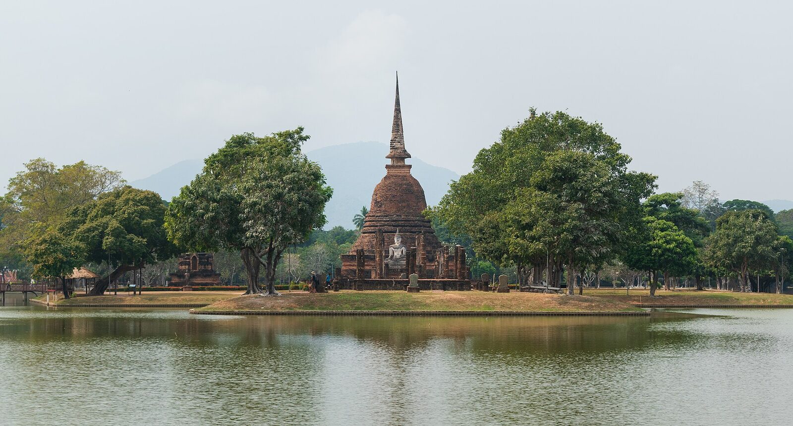 The brick chedi of Wat Sa Si reflected in the lotus pond at Sukhothai Historical Park, the setting for Loy Krathong in this guide to Thai festivals 2026