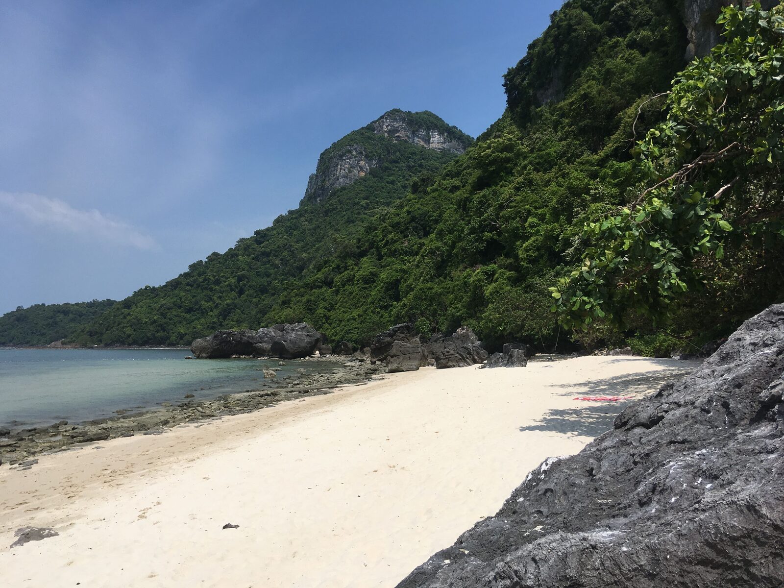Empty white-sand beach backed by jungle and limestone cliffs on Ko Wua Ta Lap, the headquarters island of Ang Thong National Marine Park in the Gulf of Thailand