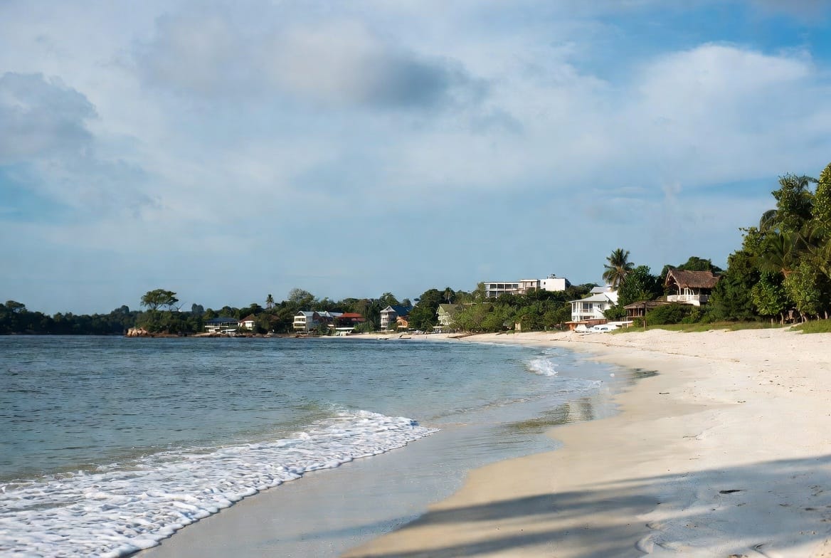 Relaxed sandy beach on Koh Chang with calm water and hillside resorts
