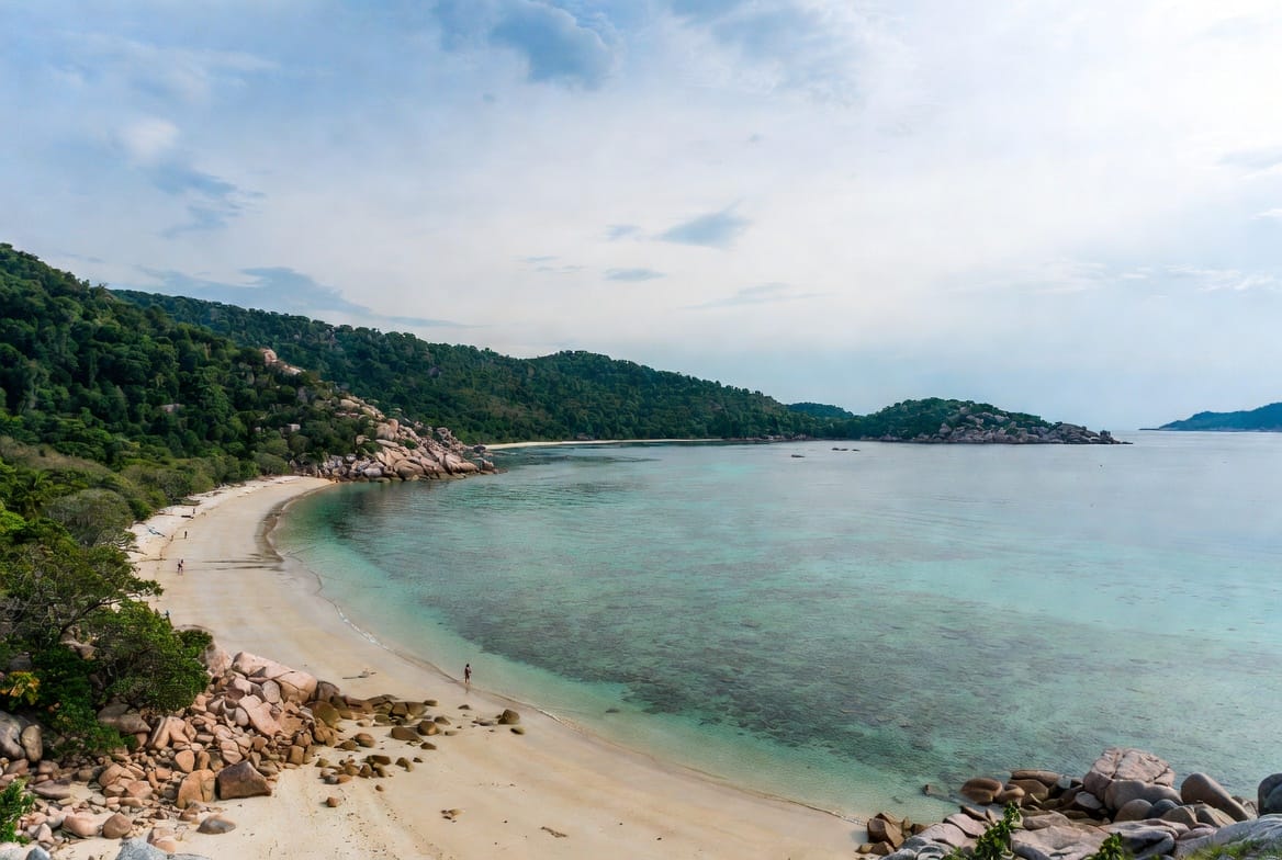 Quiet bay with clear water and rocky shoreline on Koh Tao