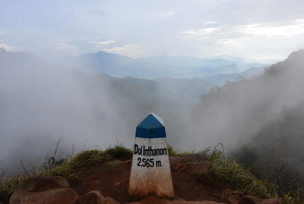 Summit marker of Doi Inthanon at 2,565 metres with misty mountain views
