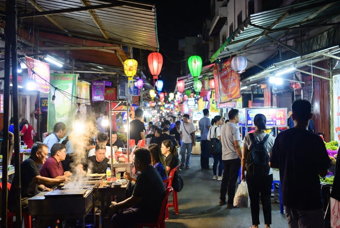Busy night market street in Hat Yai with food stalls, lights and people