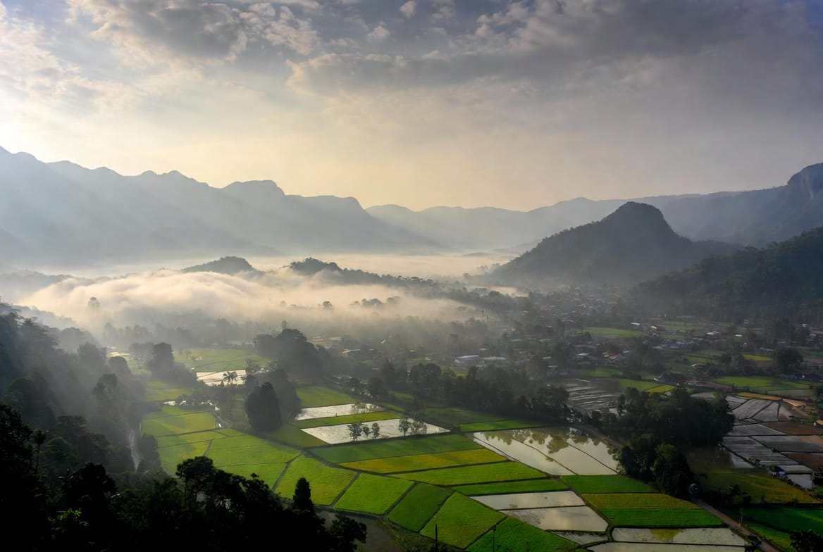 Misty morning view over Pai valley with rice fields and mountains