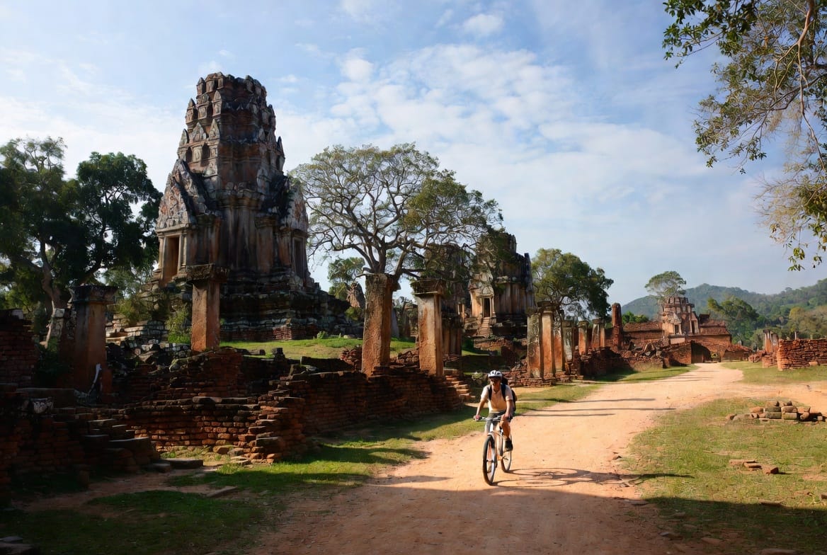 Person cycling through ancient temple ruins in Sukhothai Historical Park