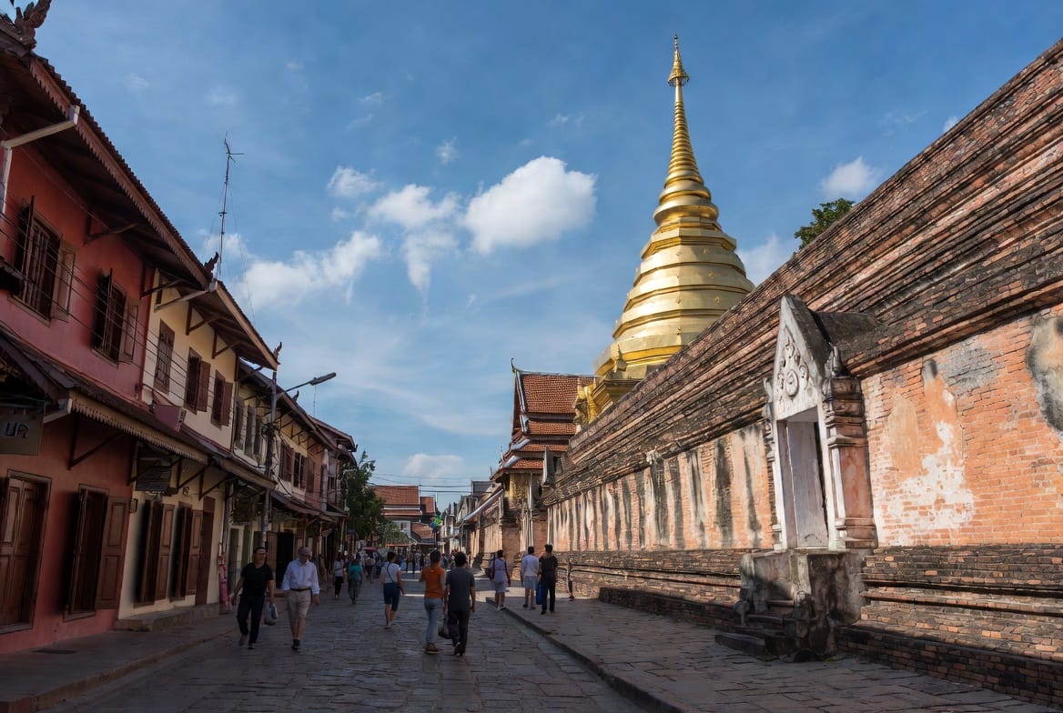 Sunny street in Chiang Mai Old City with golden temple chedi