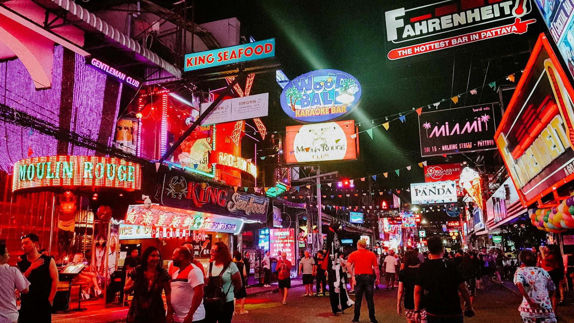 Neon-lit Walking Street in Pattaya at night with crowds and colourful signs