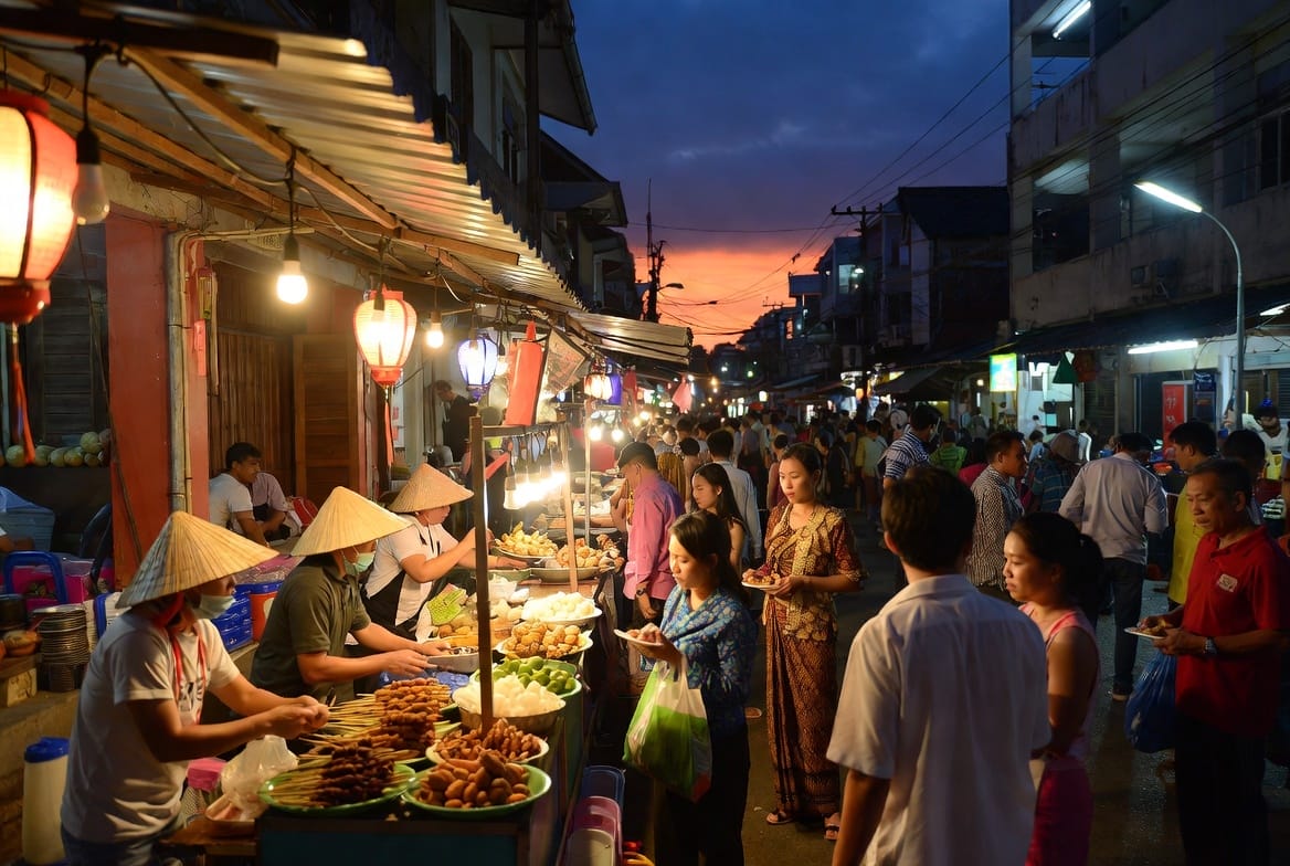 Busy night market street in Udon Thani with food stalls and people