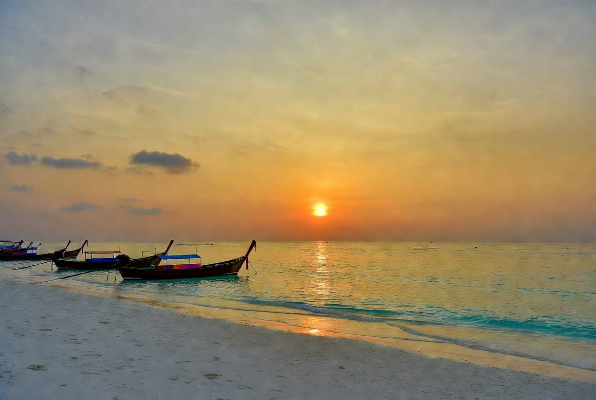Sunrise Beach on Koh Lipe with longtail boats and golden light