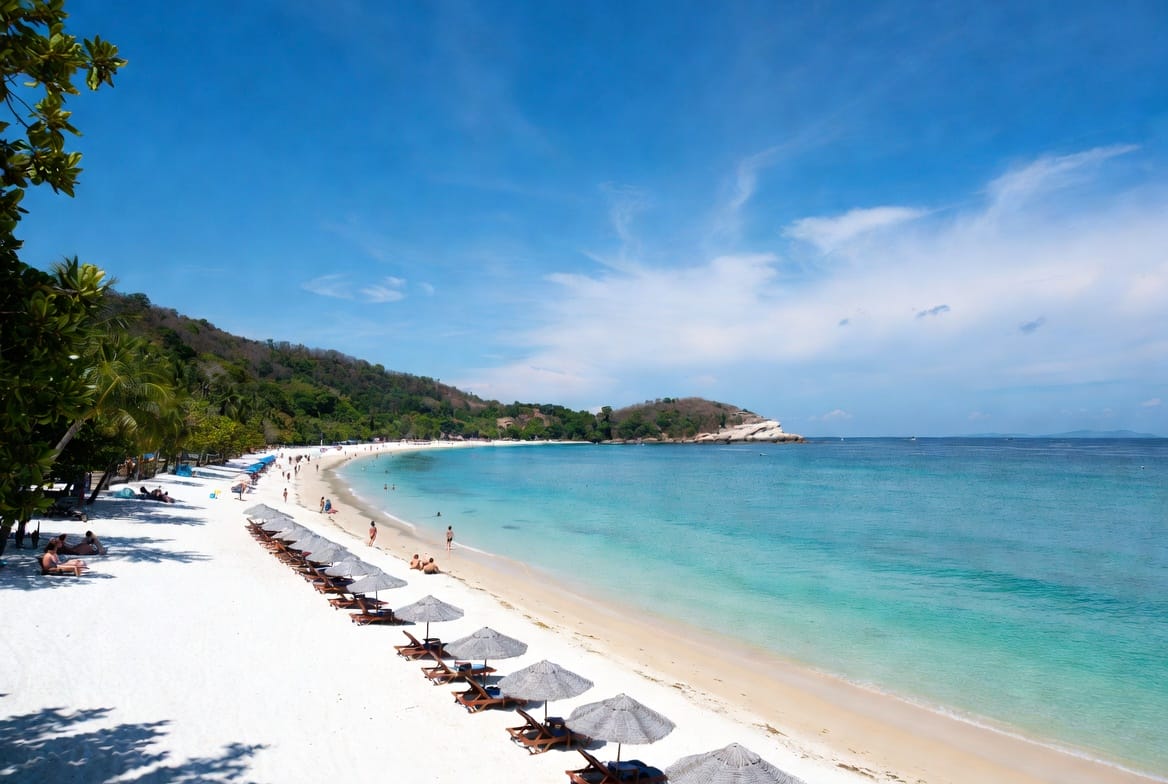 Beautiful white sand beach on Phuket with turquoise water and beach umbrellas