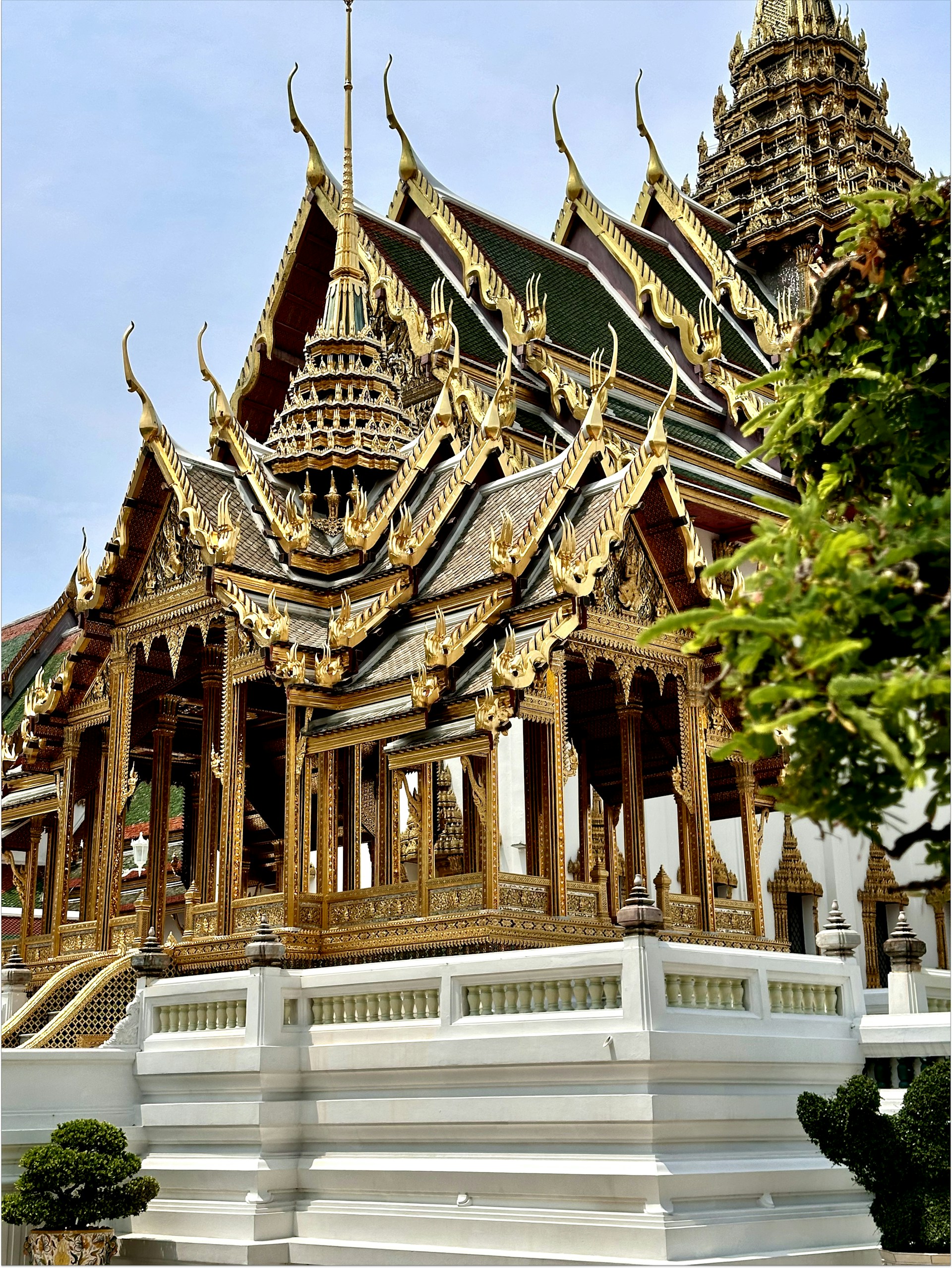 Grand Palace and golden spires of Wat Phra Kaew in Bangkok under clear blue sky
