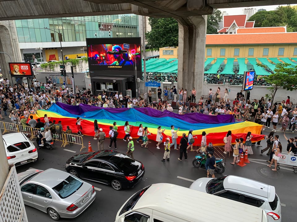 Marchers carrying a large rainbow flag during Bangkok Pride 2024